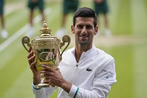 Serbia's Novak Djokovic holds the winner's trophy after his victory over Italy's Matteo Berrettini during the men's singles final match on day thirteen of the Wimbledon Tennis Championships in London, Sunday, July 11, 2021. (AP Photo/Alberto Pezzali)