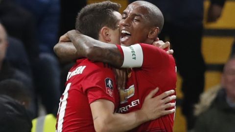 Manchester United's Ashley Young, right, hugs teammate Ander Herrera who scored his side's first goal during the English FA Cup fifth round soccer match between Chelsea and Manchester United at Stamford Bridge stadium in London, Monday, Feb. 18, 2019. (AP Photo/Alastair Grant)