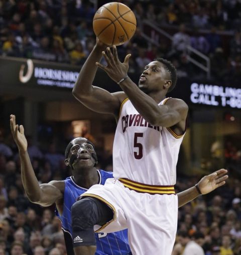 Cleveland Cavaliers' Will Cherry (5) shoots over Orlando Magic's Nikola Vucevic (9), from Montenegro, during an NBA basketball game Monday, Nov. 24, 2014, in Cleveland. (AP Photo/Tony Dejak)