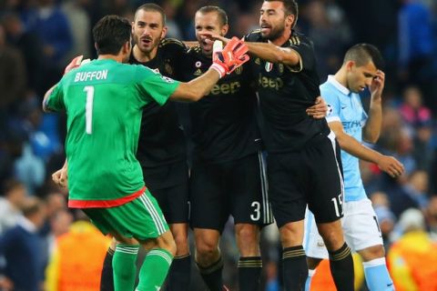MANCHESTER, ENGLAND - SEPTEMBER 15:  Gianluigi Buffon, Leonardo Bonucci, Giorgio Chiellini and Andrea Barzagli of Juventus celebrate victory as Sergio Aguero of Manchester City look dejected after the UEFA Champions League Group D match between Manchester City FC and Juventus at the Etihad Stadium on September 15, 2015 in Manchester, United Kingdom.  (Photo by Alex Livesey/Getty Images)