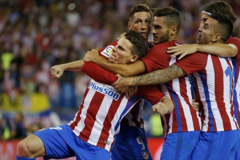 Atletico Madrid's Kevin Gameiro, left, celebrates with teammates after scoring the opening goal against Alaves during the Spanish La Liga soccer match between Atletico Madrid and Alaves at the Vicente Calderon stadium in Madrid, Sunday, Aug. 21, 2016. Gamer scored once and the match ended in a 1-1 draw. (AP Photo/Francisco Seco)