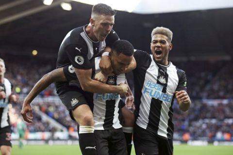 Newcastle United's Jamaal Lascelles, center, celebrates after scoring his side's first goal during the Premier League match between Newcastle and Wolverhampton at St. James' Park, Newcastle, Britain, Sunday Oct. 27, 2019.  (Owen Humphreys/PA via AP)
