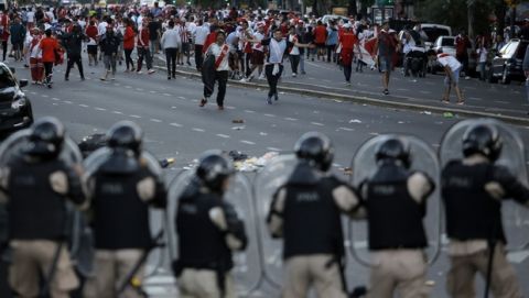 Argentina River Plate fans clash with riot police outside the Antonio Vespucio Liberti stadium prior the final soccer match of the Copa Libertadores between River Plate and Boca Juniors, in Buenos Aires, Argentina, Saturday, Nov. 24, 2018. The match has been rescheduled after the bus carrying the Boca Juniors players was attacked by River Plate fans, injuring several players. The match will be played on Sunday. (AP Photo/Sebastian Pani)