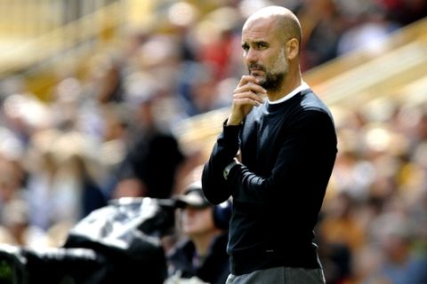 Manchester City coach Pep Guardiola stands by the bench during the English Premier League soccer match between Wolverhampton Wanderers and Manchester City at the Molineux Stadium in Wolverhampton, England, Saturday, Aug. 25, 2018. (AP Photo/Rui Vieira)