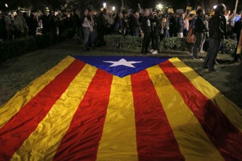 A pro-independence Catalan flag sits on the grass, as demonstrators gather outside the Catalonian Parliament to protest against the decision of a judge to jail ex-members of the Catalan government, in Barcelona, Spain, Thursday, Nov. 2, 2017. A Spanish judge has ordered nine ex-members of the government in Catalonia jailed while they are investigated on possible charges of sedition, rebellion and embezzlement. (AP Photo/Manu Fernandez)