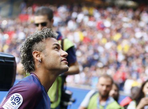 Brazilian soccer star Neymar looks up to his fans at the Parc des Princes stadium in Paris, Saturday, Aug. 5, 2017, during his official presentation to fans ahead of Paris Saint-Germain's season opening match against Amiens. Neymar would not play in the club's season opener as the French football league did not receive the player's international transfer certificate before Friday's night deadline. The Brazil star became the most expensive player in soccer history after completing his blockbuster transfer from Barcelona for 222 million euros ($262 million) on Thursday. (AP Photo/Francois Mori)