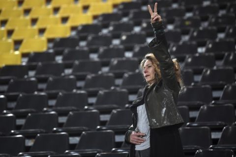 A fan makes a vicory sign the Signal Iduna Park in Dortmund, Germany, Tuesday, April 11. The first leg of the Champions League quarter final soccer match between Borussia Dortmund and AS Monaco had been cancelled to an explosion. (AP Photo/Federico Gambarini/dpa via AP)