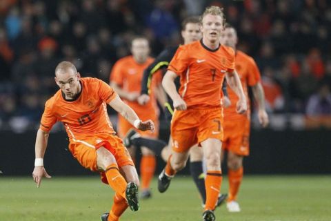 Wesley Sneijder of the Netherlands (L) shoots the ball, while teammate Dirk Kuyt watches, during their international friendly soccer match against Austria in Eindhoven February, 2011  REUTERS/Michael Kooren (NETHERLANDS - Tags: SPORT SOCCER)
