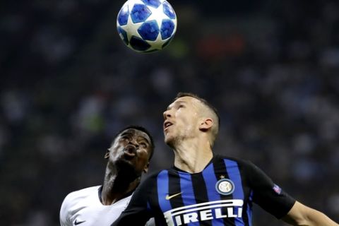 Inter Milan's Ivan Perisic, right, heads the ball flanked by Torino's Ola Aina during the Champions League, group B soccer match between Inter Milan and Tottenham Hotspur, at the Milan San Siro Stadium, Italy, Tuesday, Sept. 18, 2018. (AP Photo/Luca Bruno)