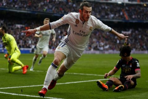 Real Madrid's Gareth Bale celebrates after scoring past Espanyol's goalkeeper Diego Lopez, left, his side's second goal during a Spanish La Liga soccer match between Real Madrid and Espanyol at the Santiago Bernabeu stadium in Madrid, Saturday, Feb. 18, 2017. Bale scored once in Real Madrid's 2-0 victory. (AP Photo/Francisco Seco)