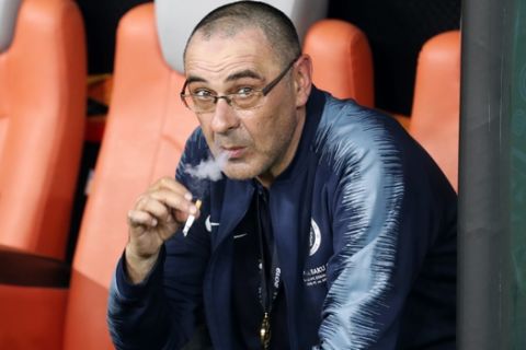 FILE - In this May 30, 2019 file photo, then Chelsea head coach Maurizio Sarri smokes a cigarette on the bench after winning the Europa League Final soccer match between Chelsea and Arsenal at the Olympic stadium in Baku, Azerbaijan. Sarri was presented as coach of Juventus Thursday, June 20, 2019 after signing a three-year contract with the club that has won Serie A for the last eight seasons. (AP Photo/Darko Bandic, file)