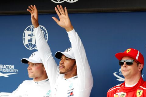 Mercedes driver Lewis Hamilton of Britain, center, celebrates after setting a pole position with second placed Mercedes driver Valtteri Bottas of Finland, left, and third placed Ferrari driver Kimi Raikkonen of Finland in the qualifying session for the Hungarian Formula One Grand Prix, at the Hungaroring racetrack in Mogyorod, northeast of Budapest, Saturday, July 28, 2018. The Hungarian Grand Prix will be held on Sunday. (AP Photo/Laszlo Balogh)