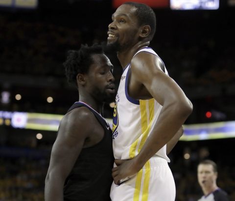 Golden State Warriors' Kevin Durant, right, smiles as Los Angeles Clippers' Patrick Beverley guards him during the second half in Game 1 of a first-round NBA basketball playoff series Saturday, April 13, 2019, in Oakland, Calif. (AP Photo/Ben Margot)