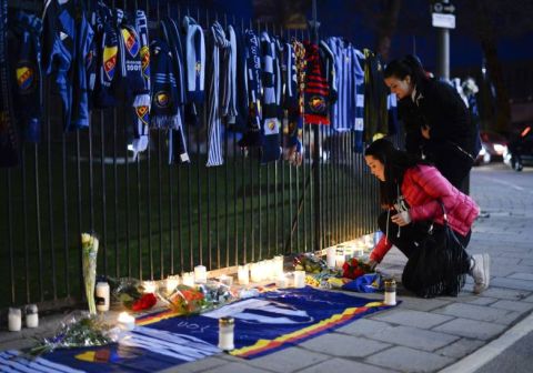 Supporters of different football clubs pay their respects outside Stockholms Stadion, laying down flowers and jerseys, after a Djurgarden IF supporter got assaulted and died of his head injuries before the season opening Swedish league match between Helsingborg IF and Djurgarden IF held at Olympia in Helsingborg on March 30, 2014. AFP PHOTO/JONATHAN NACKSTRAND