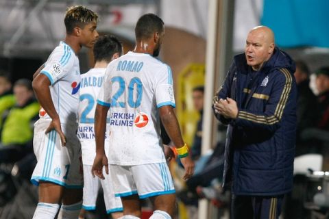 Marseille's French coach Jose Anigo, right, speaks with Marseille's Togolese midfielder Jacques-Alaixys Romao, center, Marseille's French defender Benjamin Mendy, left, and Marseille's French midfielder Mathieu Valbuena, during their League One soccer match against Valenciennes, at the Velodrome Stadium, in Marseille, southern France, Wednesday, Jan. 29, 2014. (AP Photo/Claude Paris)