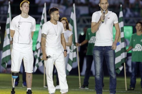 Former Chapecoense players Follmann, left, Alan Ruschel, and Neto,right, the three players that survived the air crash last year, attend a ceremony in tribute to the victims of the accident, prior to a Recopa Sudamericana first leg final soccer match between Brazil's Chapecoense and Colombia's Atletico Nacional, in Chapeco, Brazil, Tuesday, April 4, 2017. (AP Photo/Andre Penner)