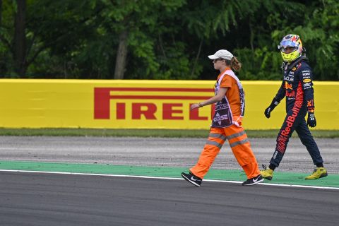 Mexican Formula One driver Sergio Perez of Red Bull Racing, right, walks back to his pits after he crashed into the track wall during the first practice session ahead of Sunday's Formula One Hungarian Grand Prix auto race, at the Hungaroring racetrack in Mogyorod, near Budapest, Hungary, Friday, July 21, 2023. (AP Photo/Denes Erdos)