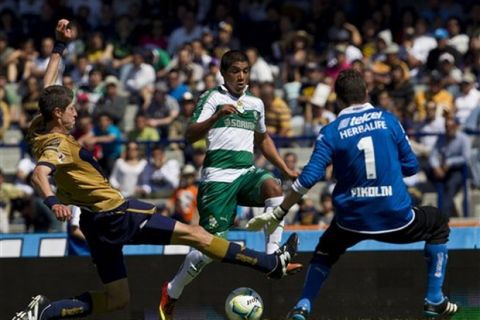 Pumas´ goalkeeper Alejandro Palacios, right, and  Pumas´ Marco Antonio Palacios, left,  fight for the ball with Santos´ Candido Ramirez during a Mexican soccer league match in Mexico City, Sunday, Feb. 3, 2013. The match ended 0-0. (AP Photo/Christian Palma)