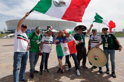 Mexico soccer fans wave their national flags outside of the Rostov Arena prior to the group F match between Mexico and South Korea at the 2018 soccer World Cup in Rostov-on-Don, Russia, Saturday, June 23, 2018. (AP Photo/Lee Jin-man)
