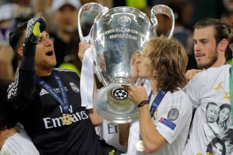 Real Madrid's Luka Modric and goalkeeper Keylor Navas, left, celebrate with the trophy after the Champions League final soccer match between Real Madrid and Atletico Madrid at the San Siro stadium in Milan, Italy, Saturday, May 28, 2016. Real Madrid won 5-4 on penalties after the match ended 1-1 after extra time.    (AP Photo/Manu Fernandez)