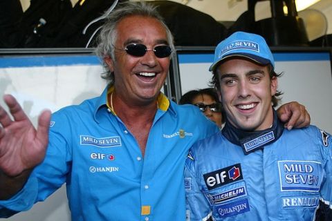 Spanish F1 driver Fernando Alonso of Renault, right, poses for the photographers with team chief Flavio Briatore, left, after he clocked the fastest time with 1:21.688 minute during the time trial to capture the pole position at Sunday's Formula One Hungarian Grand Prix on the Hungaroring race track in Mogyorod, north-east of Budapest, Hungary, on Saturday, Aug. 23, 2003. (AP Photo/MTI, Tibor Illyes)