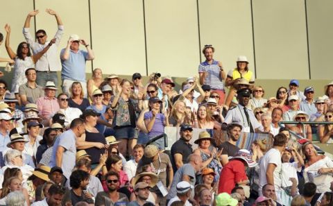 People stand up to block the panels that were reflecting the sun after Spain's Rafael Nadal complained during his Men's Singles Match against Luxembourg's Gilles Muller on day seven at the Wimbledon Tennis Championships in London Monday, July 10, 2017. (AP Photo/Tim Ireland)