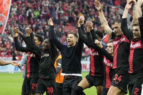 FILE - Leverkusen's head coach Xabi Alonso, centre, celebrates with his team after winning the German Bundesliga soccer match between Bayer Leverkusen and TSG Hoffenheim at the BayArena in Leverkusen, Germany, on March 30, 2024. Excitement was building in Leverkusen, Germany on Sunday ahead of local team Bayer Leverkusens expected Bundesliga title win after an outstanding season so far. (AP Photo/Martin Meissner, File)