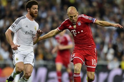 Real Madrid's midfielder Xabi Alonso (L) vies with Bayern Munich's Dutch midfielder Arjen Robben during the UEFA Champions League semifinal first leg football match Real Madrid CF vs FC Bayern Munchen at the Santiago Bernabeu stadium in Madrid on April 23, 2014.   AFP PHOTO/ JAVIER SORIANO        (Photo credit should read JAVIER SORIANO/AFP/Getty Images)