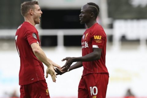Liverpool's Sadio Mane, right, celebrates with James Milner after scoring his side's third goal during the English Premier League soccer match between Newcastle and Liverpool at St. James' Park in Newcastle, England, Sunday, July 26, 2020. (Owen Humphreys, Pool via AP)