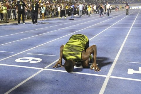 Jamaica's Usain Bolt kisses the track after winning the "Salute to a Legend " 100 meters during the Racers Grand Prix at the national stadium in Kingston, Jamaica, Saturday, June 10, 2017. Bolt started his final season with his last race on Jamaican soil and plans to retire from track and field after the 2017 London World Championships in August. (AP Photo/Bryan Cummings)
