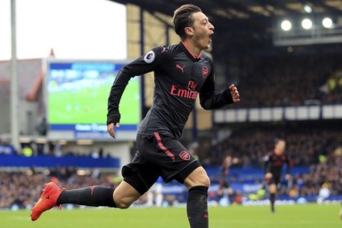 Arsenal's Mesut Ozil celebrates scoring his side's second goal against Everton during the English Premier League soccer match against Arsenal at the Goodison Park, Liverpool, England, Sunday Oct. 22, 2017. (Peter Byrne/PA via AP)