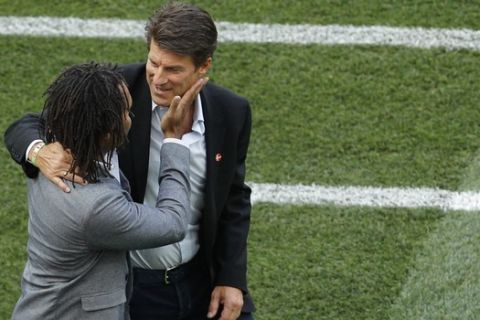 Denmark soccer legend Michael Laudrup, right, embraces France's former soccer player Christian Karembeu prior to the start of the group C match between Denmark and France at the 2018 soccer World Cup at the Luzhniki Stadium in Moscow, Russia, Tuesday, June 26, 2018. (AP Photo/Victor R. Caivano)