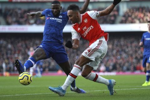 Arsenal's Pierre-Emerick Aubameyang, right, challenges for the ball with Chelsea's Antonio Rudiger during the English Premier League soccer match between Arsenal and Chelsea, at the Emirates Stadium in London, Sunday, Dec. 29, 2019. (AP Photo/Ian Walton)
