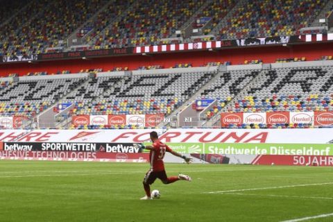 Duesseldorf's goalkeeper Florian Kastenmeier kicks the ball in front of empty stands during the German Bundesliga soccer match between Fortuna Duesseldorf and Borussia Dortmund in Duesseldorf, Germany, Saturday, June 13, 2020. Because of the coronavirus outbreak all soccer matches of the German Bundesliga take place without spectators. (Bernd Thissen/Pool via AP)