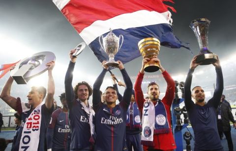 PSG players hold the French League One winner's trophies after the soccer match between Paris Saint-Germain and Stade Rennais at the Parc des Princes stadium in Paris, Saturday May 12, 2018. (AP Photo/Christophe Ena)