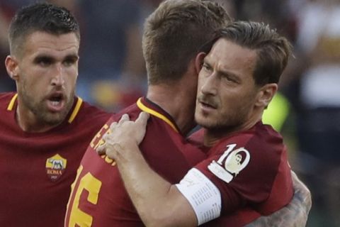 Roma's Daniele De Rossi embraces teammate Francesco Totti, right, after scoring a goal during an Italian Serie A soccer match between Roma and Genoa at the Olympic stadium in Rome, Sunday, May 28, 2017. Francesco Totti is playing his final match with Roma against Genoa after a 25-season career with his hometown club. (AP Photo/Alessandra Tarantino)