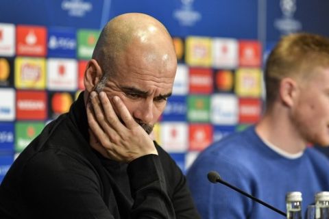 Manchester City manager Pep Guardiola looks down beside Kevin De Bruyne, right, during a press conference prior the Champions League round of 16, first leg, soccer match between FC Schalke 04 and Manchester City in Essen, Germany, Tuesday, Feb. 19, 2019. (AP Photo/Martin Meissner)