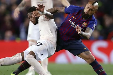 Manchester United's Frederico Fred, left, duels for the ball with Barcelona midfielder Arturo Vidal during the Champions League quarterfinal, second leg, soccer match between FC Barcelona and Manchester United at the Camp Nou stadium in Barcelona, Spain, Tuesday, April 16, 2019. (AP Photo/Manu Fernandez)