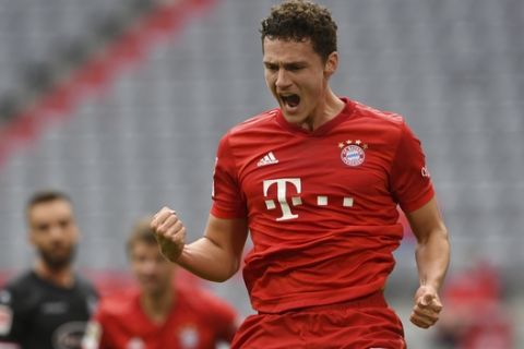 Munich's Benjamin Pavard celebrates his 2-0 after scoring during the German Bundesliga soccer match between FC Bayern Munich and Fortuna Duesseldorf in Munich, Germany, Saturday, May 30, 2020. Because of the coronavirus outbreak all soccer matches of the German Bundesliga take place without spectators. (Christof Stache/Pool via AP)