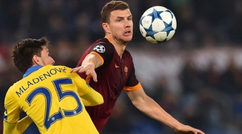 Bate Borisov's dedender Filip Mladenovic (L) vies with Roma's forward from Bosnia-Herzegovina Edin Dzeko during the UEFA Champions League football match AS Roma vs Bate Borisov on December 9, 2015 at the Olympic Stadium in Rome.  AFP PHOTO / GABRIEL BOUYS / AFP / GABRIEL BOUYS        (Photo credit should read GABRIEL BOUYS/AFP/Getty Images)