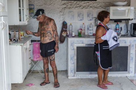 TO GO WITH AFP STORY by Javier Tovar
Brazilian football club Botafogo fan Delneri Martins Viana, a 69-year-old retired soldier, relaxes with his wife Vina at their home in Rio de Janeiro, Brazil, on January 18, 2014. Delneri has 83 tattoos on his body dedicated to Botafogo and describes himself as the club's biggest fan.   AFP PHOTO / YASUYOSHI CHIBA