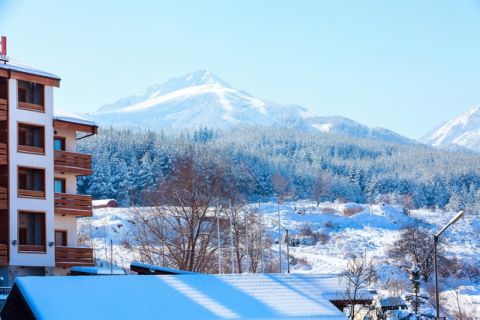 House hotel and ski slopes, snow mountains panorama in bulgarian ski resort Bansko