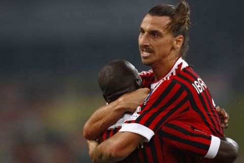 AC Milan's Zlatan Ibrahimovic (R) hugs his teammate Clarence Seedorf as he celebrates his goal against Inter Milan during their Italian Super Cup soccer match at the National Olympic Stadium, also known as the Bird's Nest, in Beijing, August 6, 2011. REUTERS/Petar Kujundzic (CHINA - Tags: SPORT SOCCER)