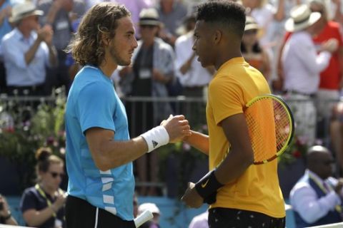 Felix Auger-Aliassime of Canada, right, shakes hands with Stefanos Tsitsipas of Greece after winning their quarterfinal singles match at the Queens Club tennis tournament in London, Friday, June 21, 2019. (AP Photo/Kirsty Wigglesworth)