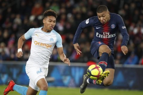 PSG's Kylian Mbappe, right, and Marseille's Boubacar Kamara vie for the ball during their French League One soccer match between Paris-Saint-Germain and Olympique Marseille at the Parc des Princes stadium in Paris, Sunday, March 17, 2019. (AP Photo/Christophe Ena)