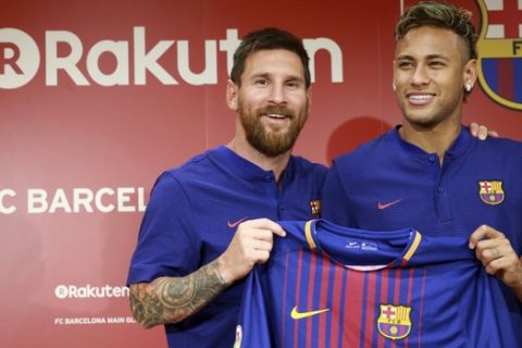 FC Barcelona's Lionel Messi, left, and Neymar pose with their new jersey during a press conference in Tokyo Thursday, July 13, 2017.  They are in the city to introduce Japanese online retailer Rakuten as the main global sponsor of the soccer club. (AP Photo/Eugene Hoshiko)