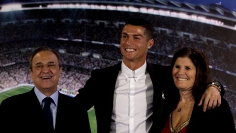 Real Madrid's Cristiano Ronaldo, center, poses his mother Maria Dolores dos Santos Aveiro, right and with the club's President Florentino Perez after signing a new contract at the Santiago Bernabeu stadium in Madrid, Spain, Monday, Nov. 7, 2016. Real Madrid have extend Ronaldo's contract until June 2021, when the three-time world player of the year will be 36. Financial details were not released, although the star forward is expected to remain the team's top-paid player. (AP Photo/Paul White)