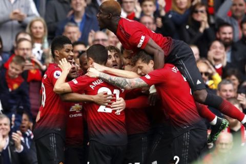 Manchester United's Juan Mata, center obscured, celebrates scoring his side's first goal of the game with teammates during their English Premier League soccer match against Chelsea at Old Trafford, Manchester, England, Sunday, April 28, 2019. (Martin Rickett/PA via AP)