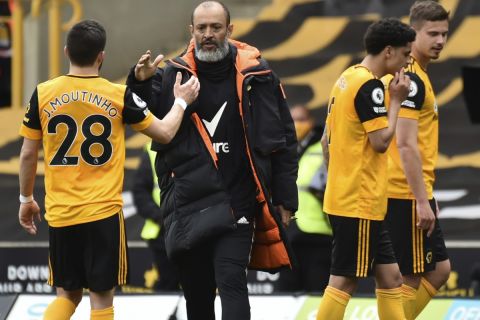 Wolverhampton Wanderers' head coach Nuno Espirito Santo, center, greets Wolverhampton Wanderers' Joao Moutinho at the end of the English Premier League soccer match between Wolverhampton Wanderers and Brighton & Hove Albion at the Molineux Stadium in Wolverhampton, England, Sunday, May 9, 2021. (AP Photo/Rui Vieira, Pool)