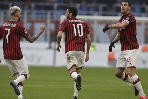 AC Milan's Hakan Calhanoglu, center, celebrates with his teammates Samu Castillejo, left, and Alessio Romagnoli, after scoring his side's first goal during a Serie A soccer match between AC Milan and Hellas Verona, at the San Siro stadium in Milan, Italy, Sunday, Feb. 2, 2020. (AP Photo/Luca Bruno)